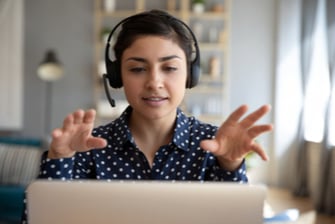 employee working from home on laptop talking on headset